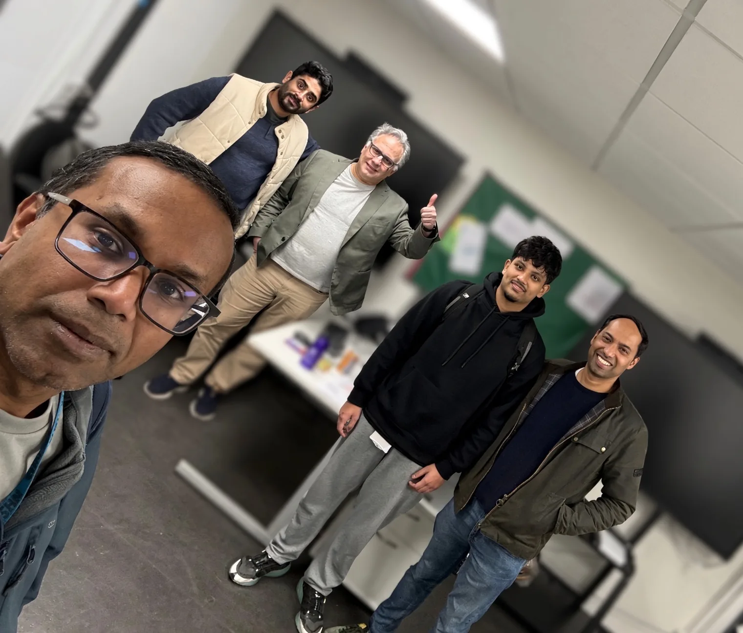 Five men in a meeting room, with UK GPs Dr Rofique Ali at front left and Dr Sabir Zaman, a GP Partner at Bethnal Green Health Centre, at right.